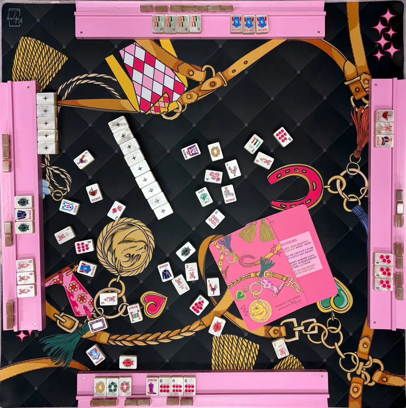 Bespoke Mahjong tiles and pink racks on a black and gold equestrian mat