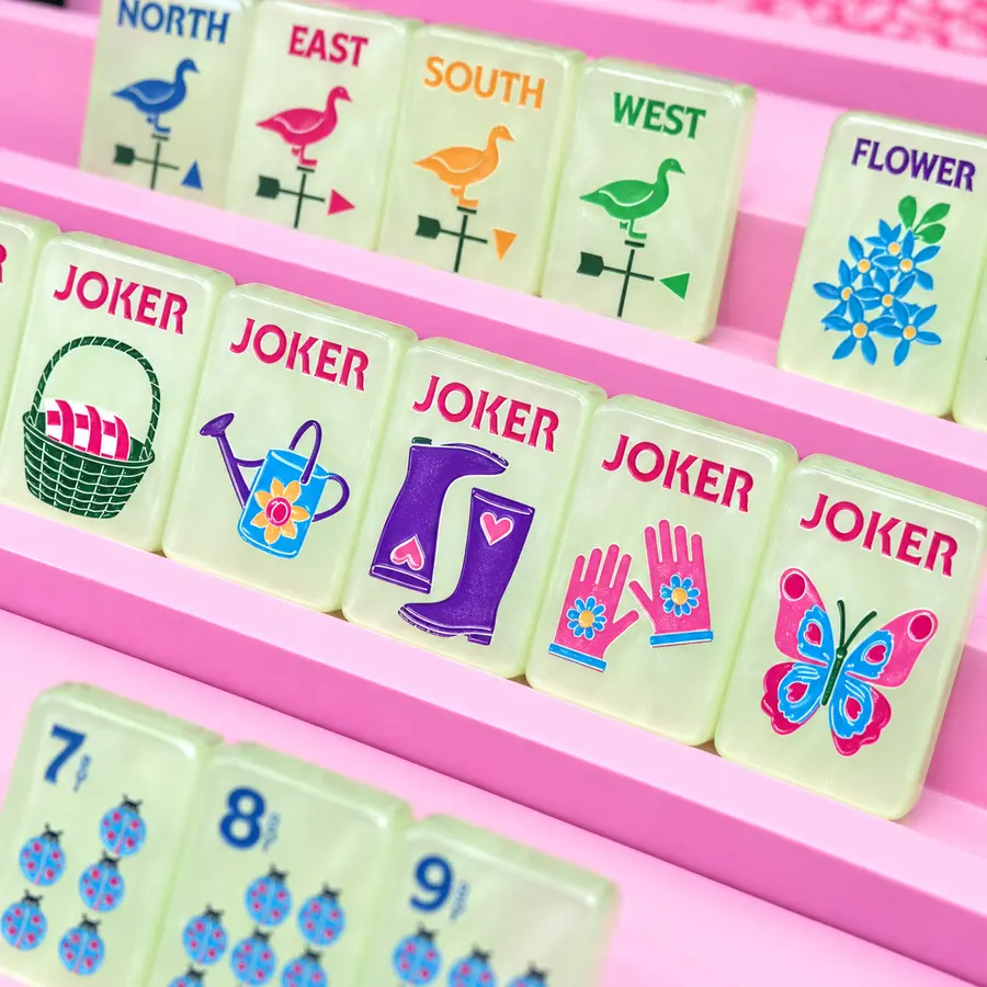A close-up of pale green Bespoke Mahjong tiles in pink racks